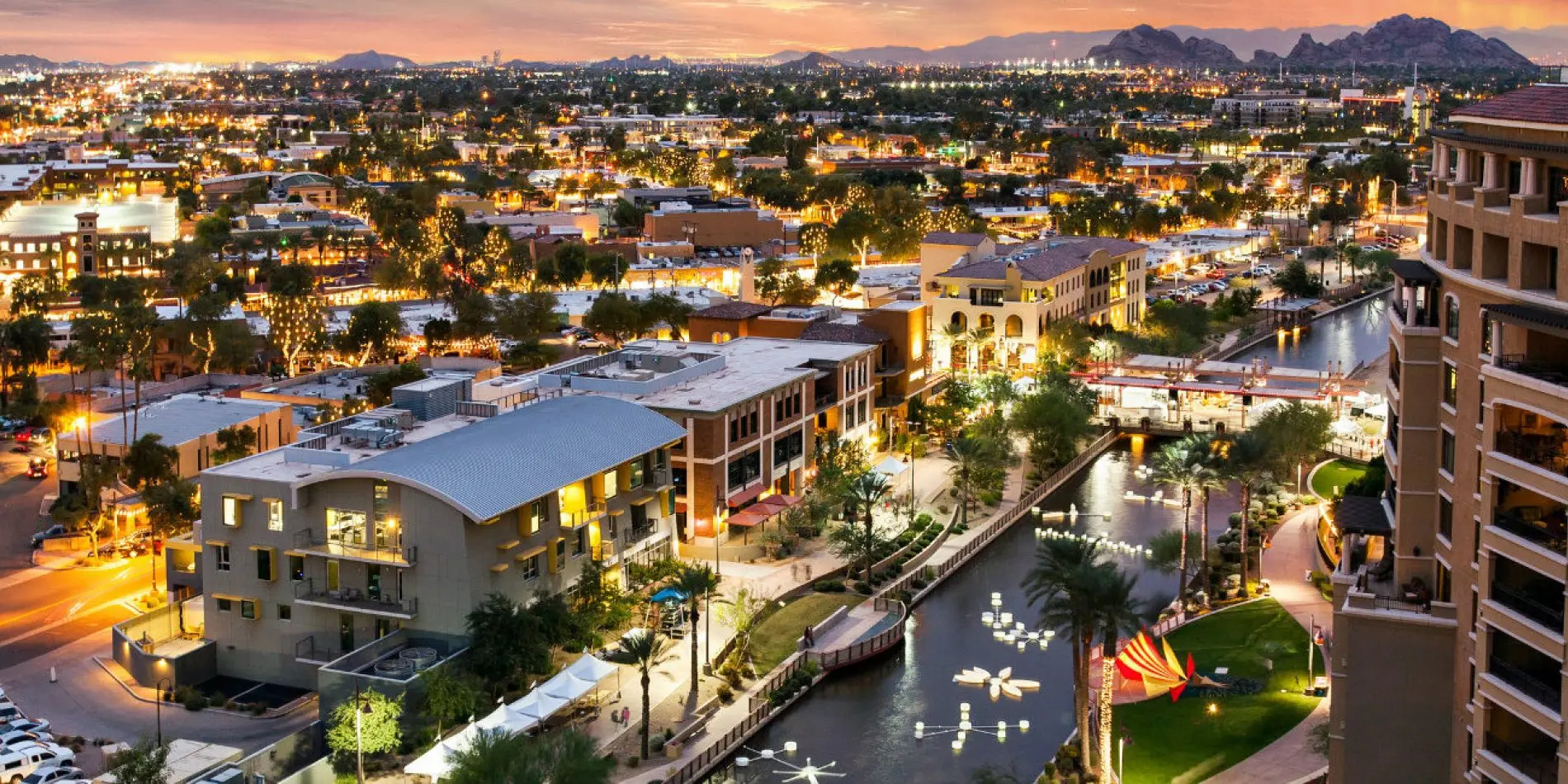 Aerial view of Old Town Scottsdale canal at dusk with Camelback Mountain in the distance