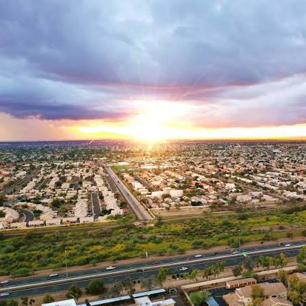 Aerial view of Peoria area neighborhoods at sunset with highway and desert landscape